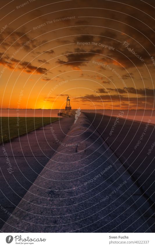 Quermarkenfeuer auf einer Mole bei Sonnenuntergangs-Himmel in der Nähe von Wilhelmshaven leuchtfeuer leuchtturm quermarkenfeuer mauer maritim seefahrt