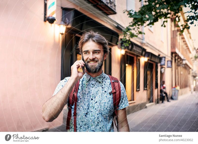 Mann, der auf der Straße telefoniert. Erwachsener Glück Lifestyle Kaukasier Fröhlichkeit Lächeln Spaß Liebe Freude Freizeit heiter Lachen Termin & Datum Genuss