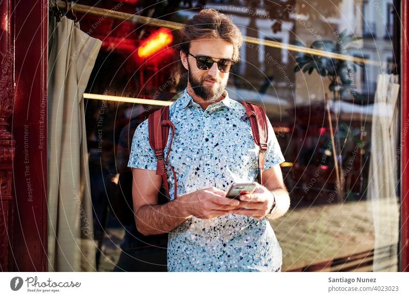 Mann schaut auf der Straße auf sein Telefon. Erwachsener Glück Lifestyle Kaukasier Fröhlichkeit Lächeln Spaß Liebe Freude Freizeit heiter Lachen Termin & Datum