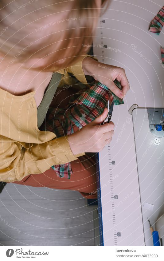 Draufsicht auf eine Frau bei der Arbeit in ihrer Nähwerkstatt, Nähen Gewebe Schneider Material Näherin Bekleidung Nadel Handwerk Faser Textil Business Arbeiter