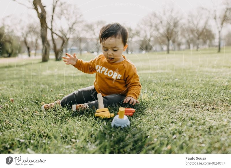 Kleinkind spielt mit woodem Spielzeug im Park Frühling im Freien Spielen Kindergarten Außenaufnahme Kindheit Freude Farbfoto Spielplatz Mensch Tag Glück