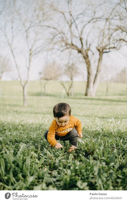 Kind spielt im Park Kaukasier 1-3 Jahre Farbfoto Kindheit Mensch Kleinkind Tag Außenaufnahme Lifestyle Freude niedlich Gras Frühling Leben authentisch