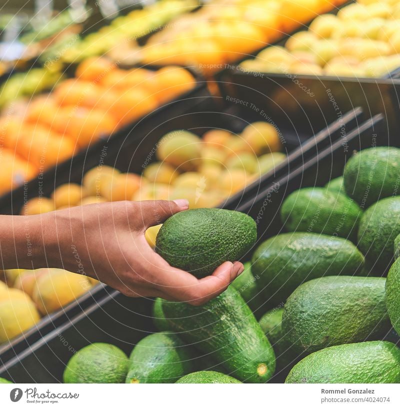 Junge Frau wählt Avocados im Lebensmittelgeschäft. Konzept der gesunden Ernährung, Bio, vegetarisch, Diät. Selektiver Fokus. Gemüse Guacamole-Zutaten Aguacate