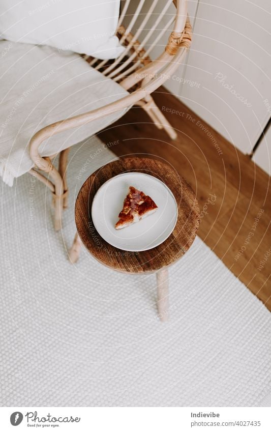 Ein Stück hausgemachter Apfelkuchen auf einem Holzhocker im Wohnzimmer Pasteten Vanille Dessert Kuchen süß Scheibe Lebensmittel Frucht warm lecker geschmackvoll