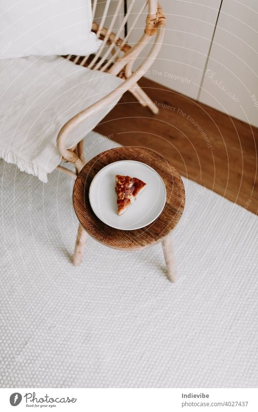 Ein Stück hausgemachter Apfelkuchen auf einem Holzhocker im Wohnzimmer Pasteten Vanille Dessert Kuchen süß Scheibe Lebensmittel Frucht warm lecker geschmackvoll