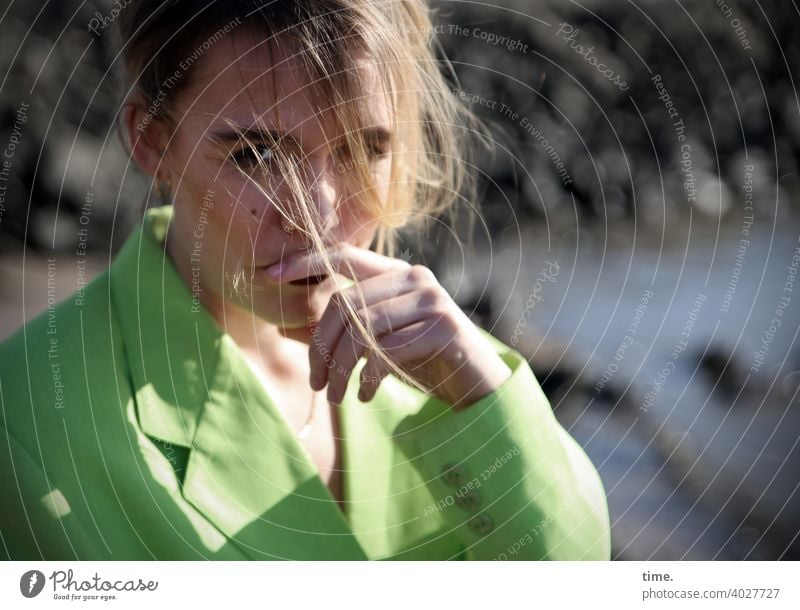 Lara Frau blick blond Haare nachdenklich jacke grün neongrün hand steine ufer wasser