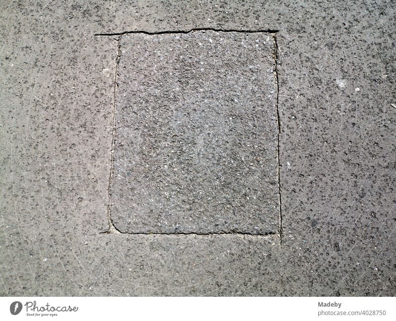 Markiertes Rechteck in grauem Asphalt an der ehemaligen Berliner Mauer am Checkpoint Charlie in der Hauptstadt Berlin, Deutschland Straße Fahrbahn Frau