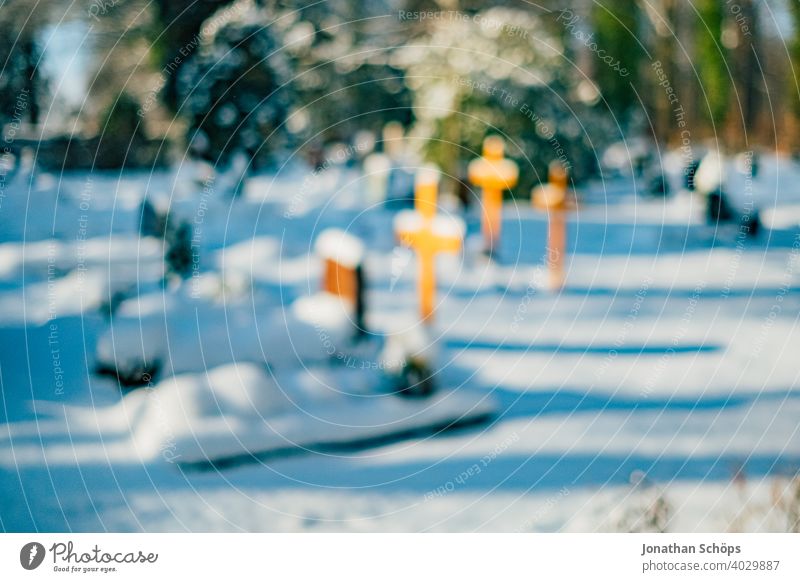 Grab auf Friedhof im Winter bei Schnee Tod und Ewigkeit Abschied Beerdigung Bokeh Christentum Coronatote Coronawinter Gebet Gedenken Glaube Gott Gottesacker