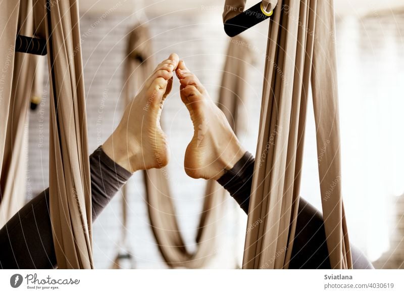 Nahaufnahme einer Frau die Beine in einer Hängematte tun aerial Yoga-Übungen in der Turnhalle Antenne Fitnessstudio schließen Lifestyle Gleichgewicht passen