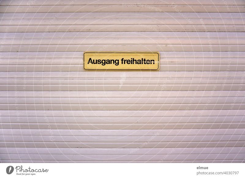 "Ausgang freihalten" steht auf einem Schild an einem Garagentor / Rücksichtnahme Tor Mitteilung Hinweisschild Schilder & Markierungen Ausfahrt Einfahrt Eingang