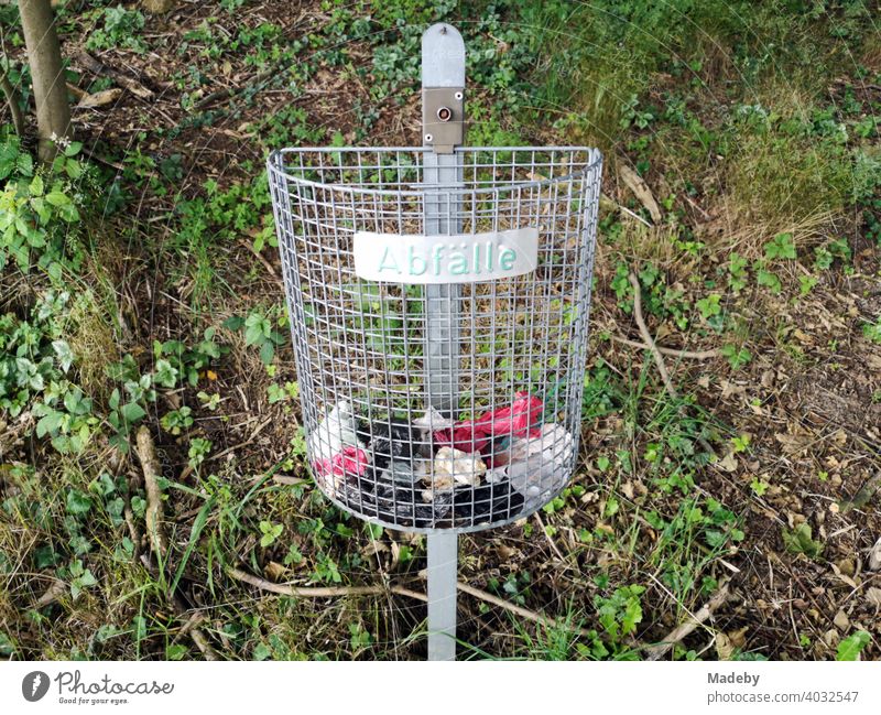 Grauer Drahtkorb für Abfälle am Waldrand in Oerlinghausen am Hermannsweg im Teutoburger Wald in Ostwestfalen-Lippe Mülleimer Korb Papierkorb Abfall Umwelt