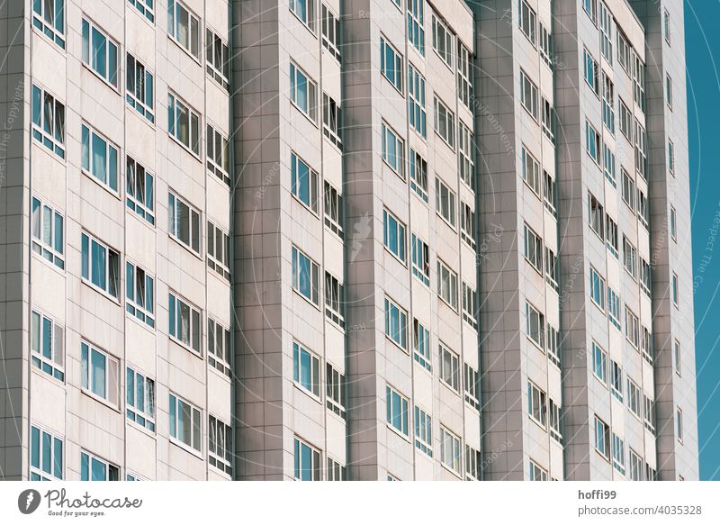 Hochhausfassade mit blauem Himmel - die Fester spiegeln das Blau, keiner zu sehen vereinsamen Fassade Fenster Außenaufnahme trist Enttäuschung modern