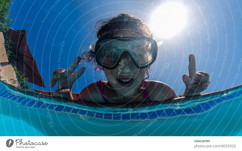 Kleines Mädchen am Beckenrand. Ansicht von unten. aktiv Bikini blau Blasen Kind Kindheit Tauchen genießen Gesicht Spaß lustig Schutzbrille Fröhlichkeit