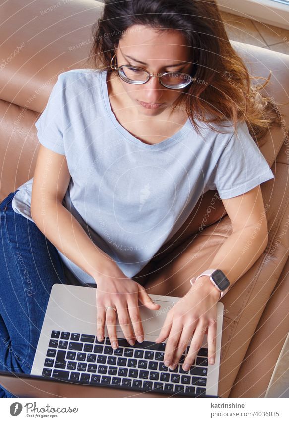 Junge Frauen verwenden einen Laptop, während sie zu Hause auf dem Sofa sitzen jung anhaben Attrappe T-Shirt lernen Schüler Lifestyle Jeanshose Brille ernst