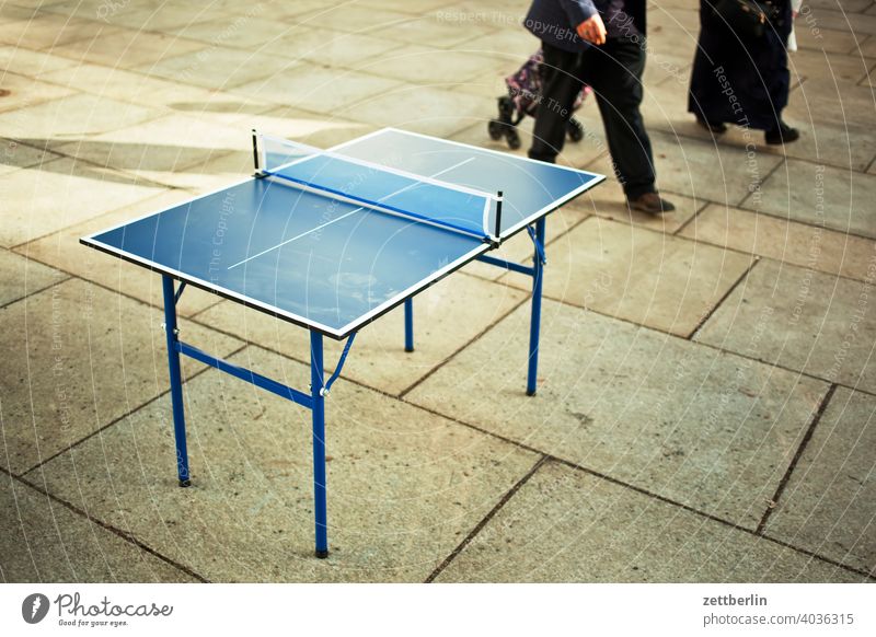 Tischtennisplatte und uninteressierte Passanten bein desinteresse gehen gehweg gehwegplatte kinderladen markt mensch passant platz spiel spielplatz sport