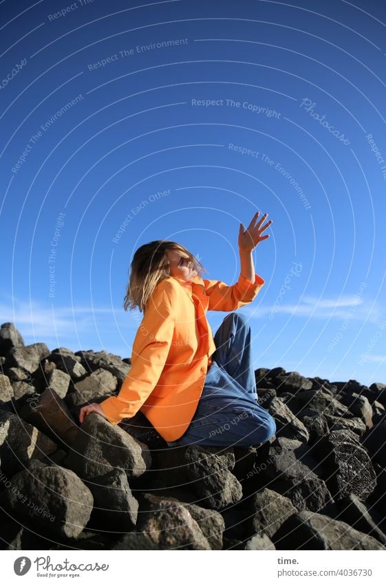 Lara frau jacke wellenbrecher steine himmel sitzen hand schutz sonnig jeans aufstützen abstützen wolken