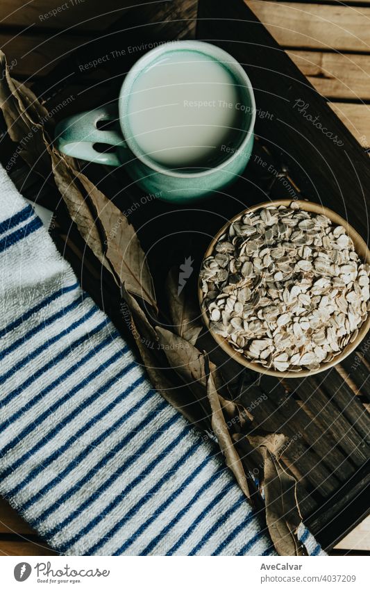 Tasse Hafermilch mit Hafersamen in einer Schüssel über einem Holzbrett melken Lebensmittel Gesundheit Korn organisch Samen Ernährung Müsli weiß natürlich