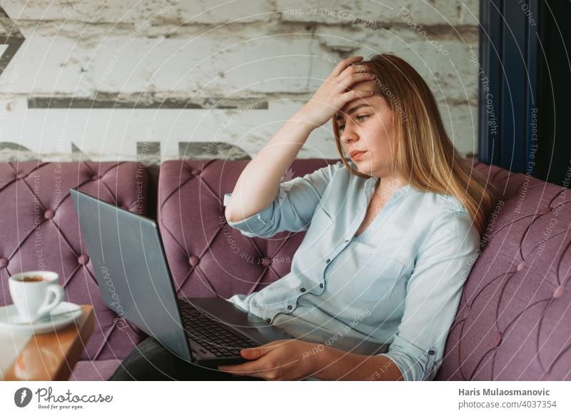 Frau mit Kopfschmerzen bei der Arbeit am Laptop, stressige Arbeit, schlechte Nachrichten per E-Mail Erwachsener Rückenhaltung Haltungsfehler schön Business