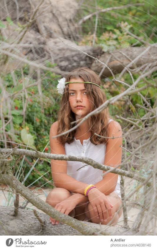 Junges Mädchen mit Blume im Haar sitzt am Strand Urlaub Frau jubg schön sommer Ferien & Urlaub & Reisen Sand Freude Erholung Gebüsch Sträucher Äste Bäume Grün