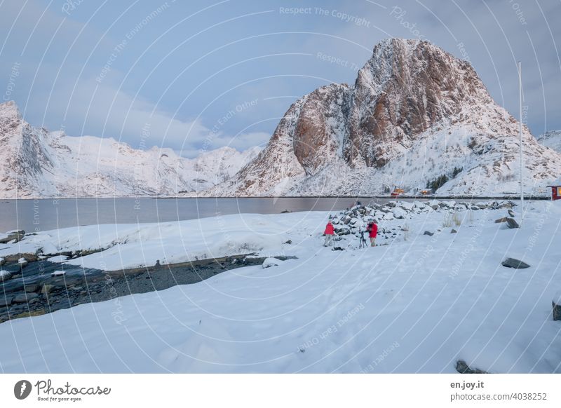 Fotografen im Schnee an einem Fjord umrahmt von felsigen Bergen Lofoten Hamnøy Winter Felswand Felsen Norwegen Skandinavien Ferien & Urlaub & Reisen Tourismus