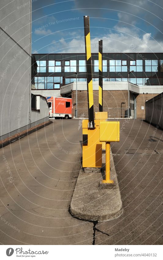 Gelbe Schranken an der Einfahrt zu einem modernen Krankenhaus im Sommer in Paderborn in Ostwestfalen-Lippe schranke Parkdeck Ambulanz Zufahrt Rampe Warnbake