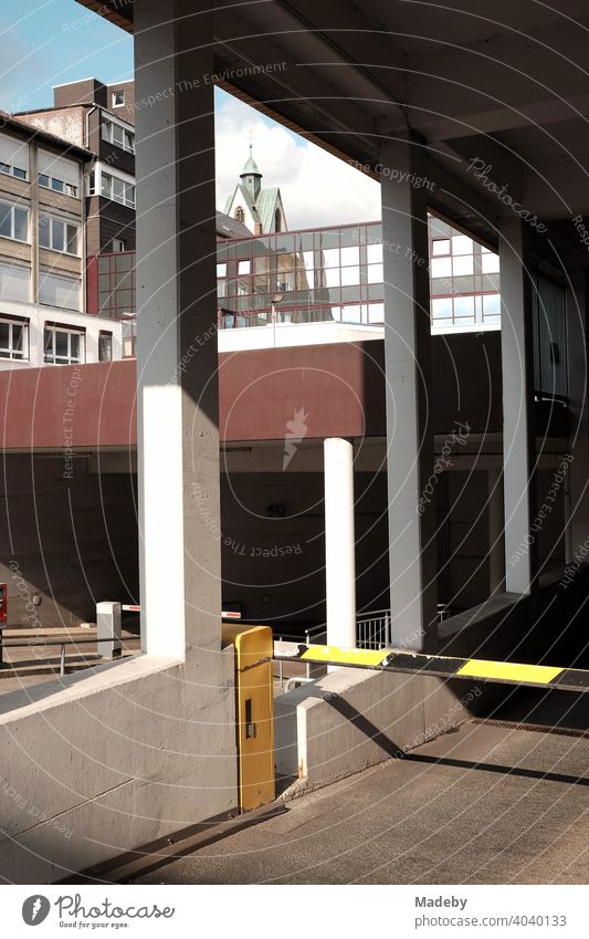 Schranke an der Einfahrt zu der Parkgarage eines Krankenhaus in Paderborn in Ostwestfalen-Lippe Warnbaken Parken Parkhaus Sonnenschein Architektur Beton Säule