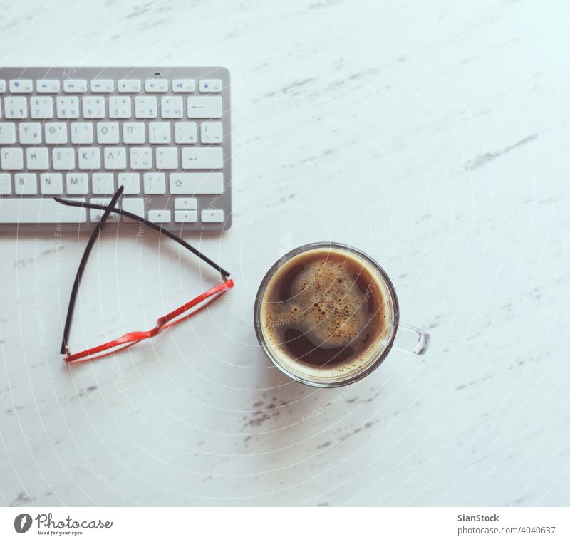 Arbeitsplatz mit Brille, Kaffee und Tastatur. Laptop Top Schreibtisch Ansicht Tisch Büro Computer Tasse Desktop weiß Keyboard oben Business Hintergrund Raum