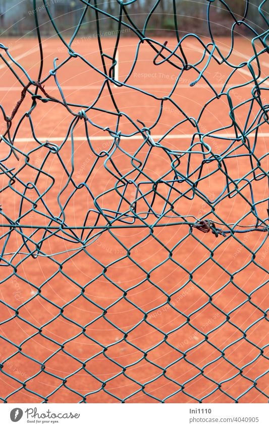 Tennisplatz unprofessionelle Reparatur am Maschendrahtzaun Maschendrath maschendrahtschaden notdürftig repariert grün türkis Spielfeld Loch Schaden unschön