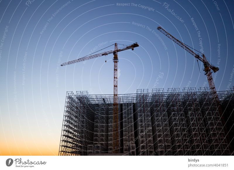 Großbaustelle, Errichtung einer Industrie- Stahlkonstruktion, zwei Baukräne in der Abenddämmerung Baustelle Kran Industrieanlage bauen Arbeit & Erwerbstätigkeit