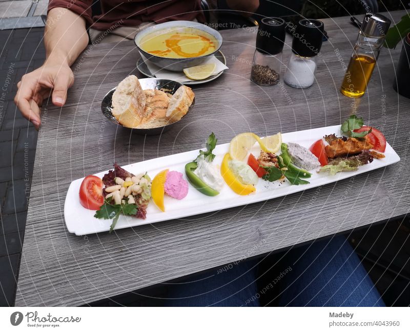 Langer schmaler Teller mit bunten türkischen Vorspeisen, Brotkorb und Suppenteller auf dem Tisch in einem Restaurant im Nordend von Frankfurt am Main in Hessen