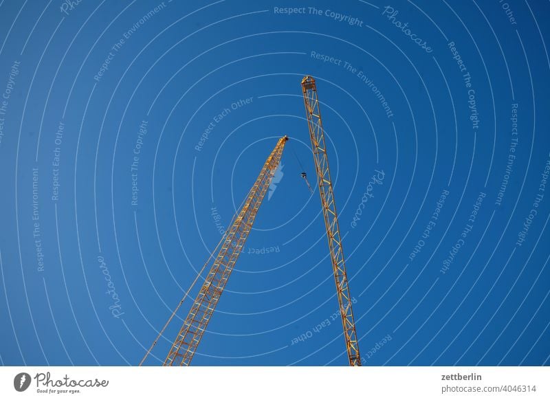 Zwei Kräne auf Tuchfühlung Hochbau außen baugewerbe bauindustrie baustelle drehkran froschperspektive gebäude gewerk himmel himmelblau menschenleer montage