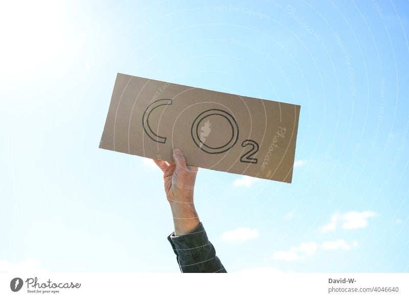 CO2 - Mann hält ein Schild in die Luft Umweltaktivist CO2-Ausstoß Nachhaltigkeit Klimawandel Umweltschutz Umweltverschmutzung Zukunftsangst Luftverschmutzung