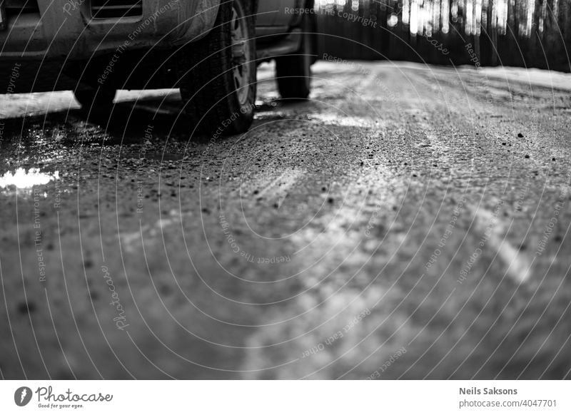 Nahaufnahme von Autoreifen im Winter auf dem Feldweg mit Eis, Schnee und Kies bedeckt unbefestigter Weg Automobil Hintergrund PKW schließen kalt Bedingungen