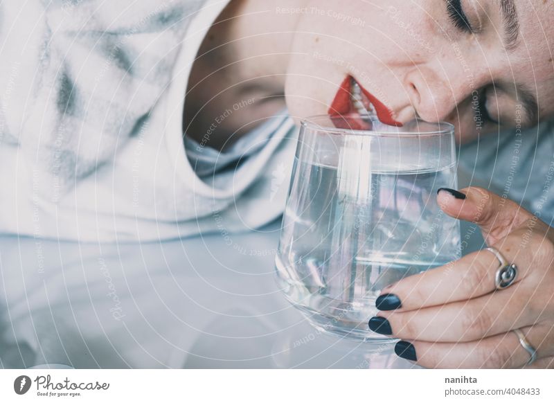 Porträt einer jungen Frau, verdeckt durch ein Glas mit einem transparenten Getränk Depression blau traurig mental Gesundheit Psychologie Traurigkeit depressiv