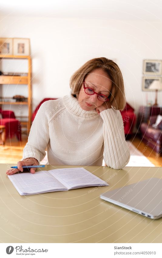 Senioren mittleren Alters, die zu Hause am Computer arbeiten Frau Laptop reif Menschen eine Person Lifestyle Schreibtisch benutzend trinken Brille attraktiv