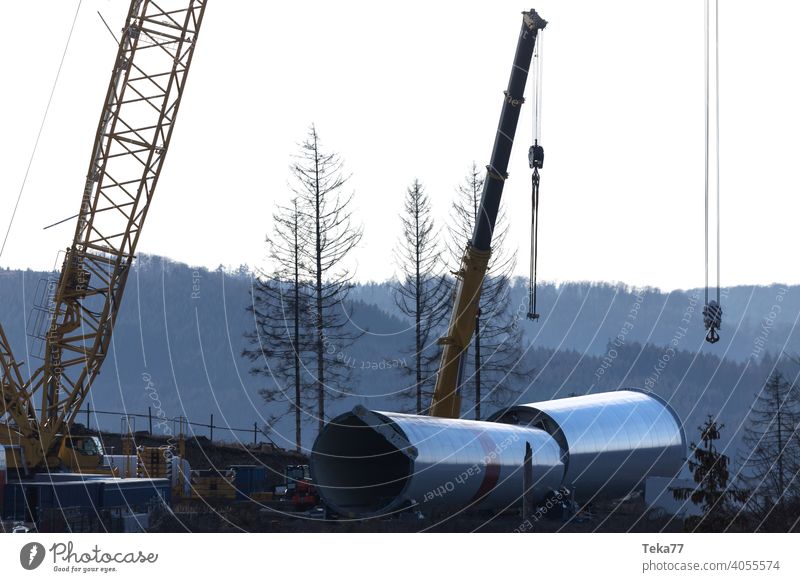 eine moderne Windkraftanlagen-Baustelle Windkraftanlagenbau Baukran Schwerlastkran Windrad Abend Ökostrom Winter Blauer Himmel gelb schwer Farben im Freien