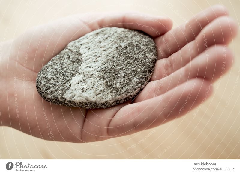 Frau hält Stein mit Wellenformen als Symbol der Balance für die Meditation Hand Gleichgewicht Harmonie Zen Felsen Windstille Frieden Spa Natur Gesundheit