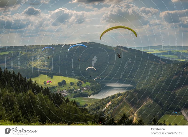 Ausschwärmen  der Gleitschirmflieger Gleitschirme Paraglise fliegen Sport springen hoch Mann Himmel Wasser Stausee Landschaft Wald Wiese Horizont Natur