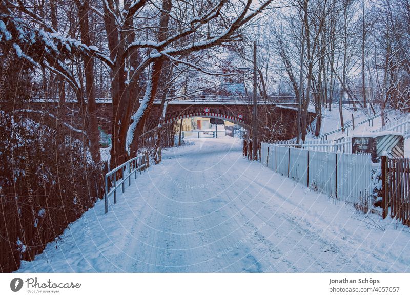 Straße im Winter bei Schnee vor Bahndamm Tunnel Unterführung Brücke Glatteis kalt Außenaufnahme Verkehrswege Glätte Wege & Pfade Autofahren Straßenverkehr