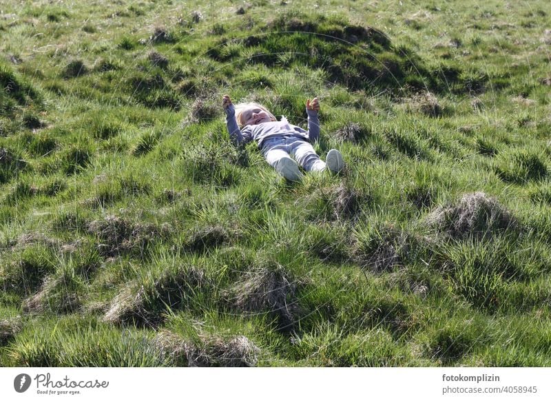 Kind liegt auf einer grünen Graswiese Wiese Kindheit Wachstum Lebensfreude Erholung Naturerlebnis Zufriedenheit Wohlgefühl Gesundheit Vorschulkind