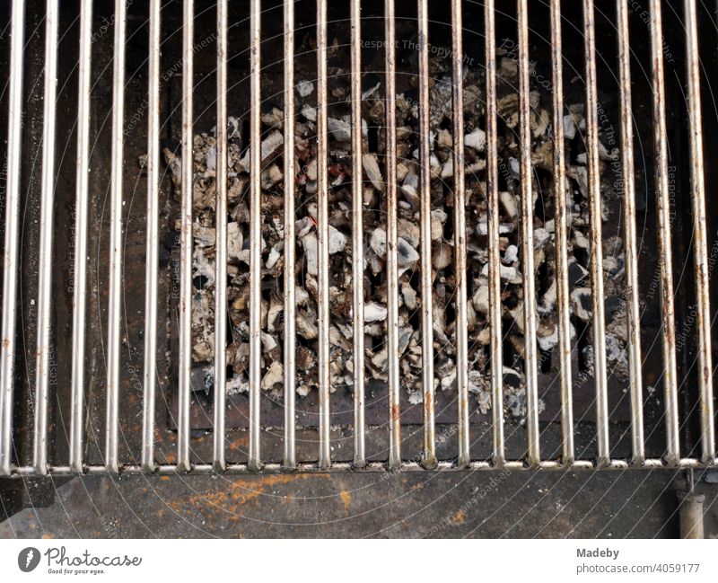 Grillrost über Resten von Holzkohle auf einem rostigen alten Holzkohlegriil bei einem Barbecue in Rudersau bei Rottenbuch im Kreis Weilheim-Schongau in Oberbayern