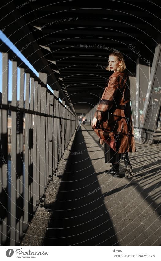 Lara skeptisch geheimnisvoll urban schatten sonnig brückenpfeiler metall ledermantel Haare blond blick Frau gehen umschauen