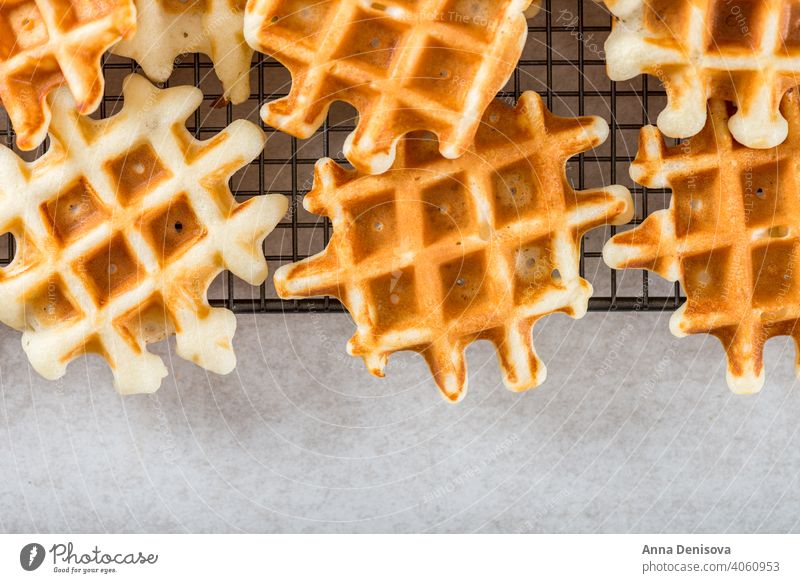 Traditionelle hausgemachte belgische Waffeln auf hellem Hintergrund Belgier Frühstück Dessert Blaubeeren Himbeeren Sirup gebacken süß frisch Beeren Gebäck