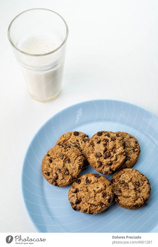 Teller mit Schokoladenkeksen und ein Glas Milch Frühstück melken natürlich Keks Chip trinken süß Lebensmittel Biskuit Farbfoto Mahlzeit hölzern heimisch Gebäck