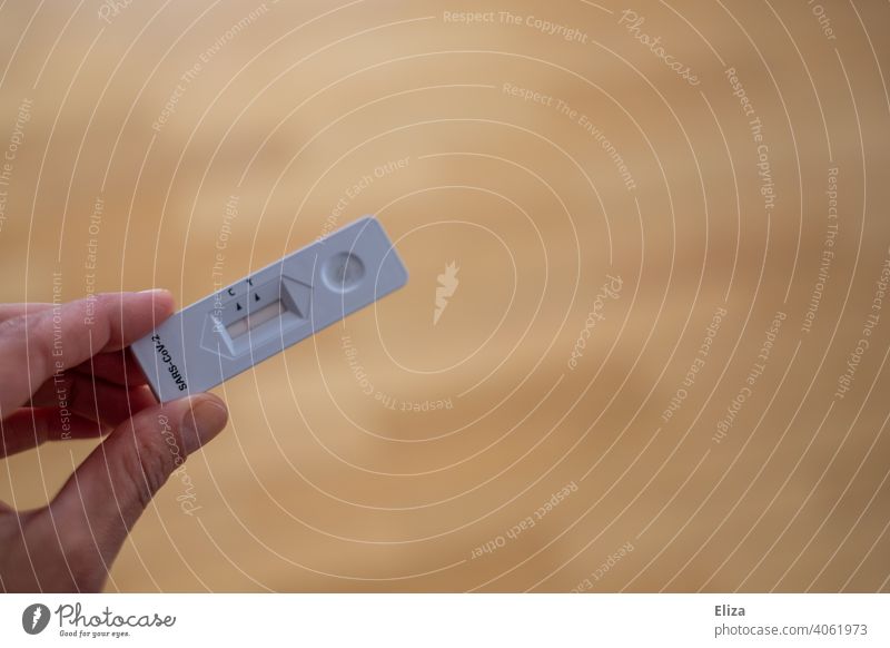 Person hält einen negativen Corona Schnelltest/Selbsttest in der Hand testen Vorsicht Coronavirus zuhause privat Test Coronatest Selbstest