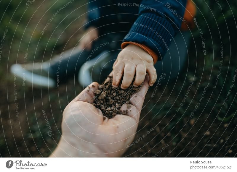 Kind pflückt Erde aus der Hand des Vaters Boden Kindheit Bildung Nahaufnahme erkunden authentisch Farbfoto Fröhlichkeit Kaukasier Freude Lifestyle Tag Spielen