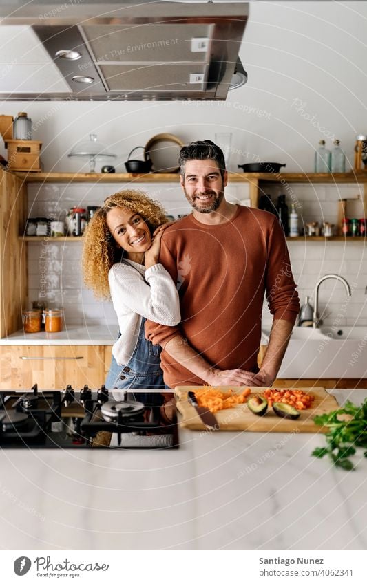 Pärchen, das sich in der Küche umarmt. Lebensmitte Paar Liebe Essen zubereiten heimwärts gemütlich Kaukasier Partnerschaft vorbereitend Frau Glück Person Herd