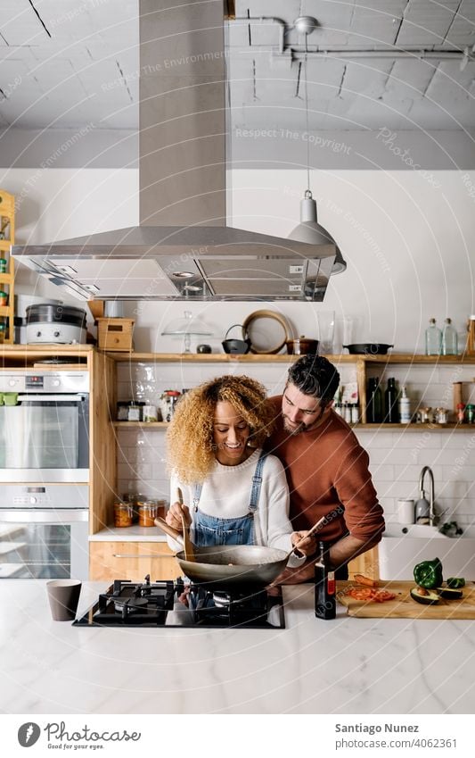 Ehepaar bereitet Essen in der Küche vor. Lebensmitte Paar Liebe Essen zubereiten heimwärts gemütlich Kaukasier Partnerschaft vorbereitend Frau Glück Person Herd