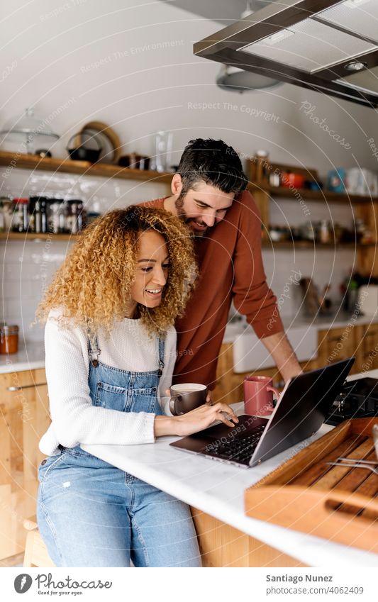 Ehepaar schaut in der Küche auf einen Laptop. Lebensmitte Paar Liebe Essen zubereiten heimwärts gemütlich Kaukasier Partnerschaft vorbereitend Frau Glück Person