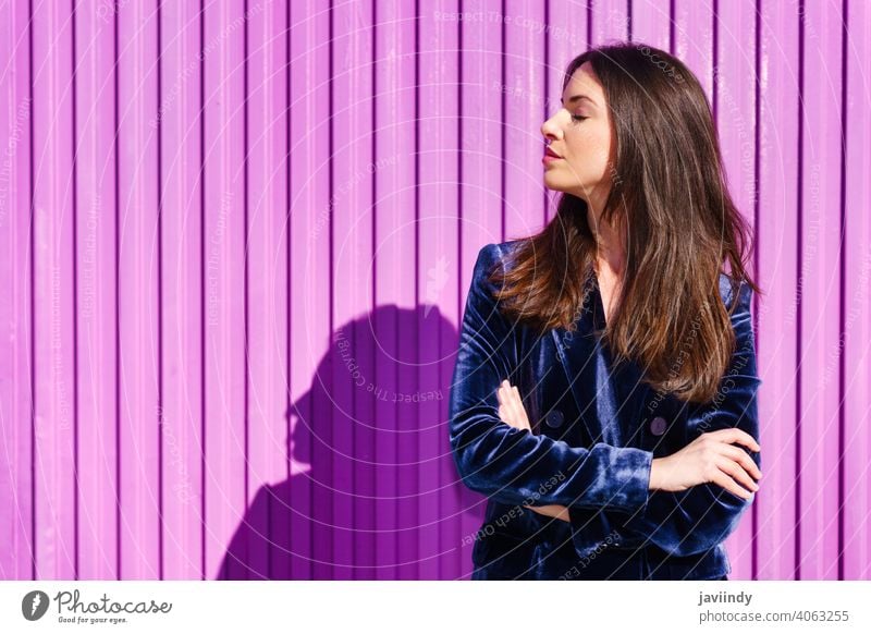 Frau in blauem Anzug posiert mit geschlossenen Augen in der Nähe eines rosa Rollladens. Mädchen zugeklappt Person Mode Model Lifestyle urban Hintergrund Dame